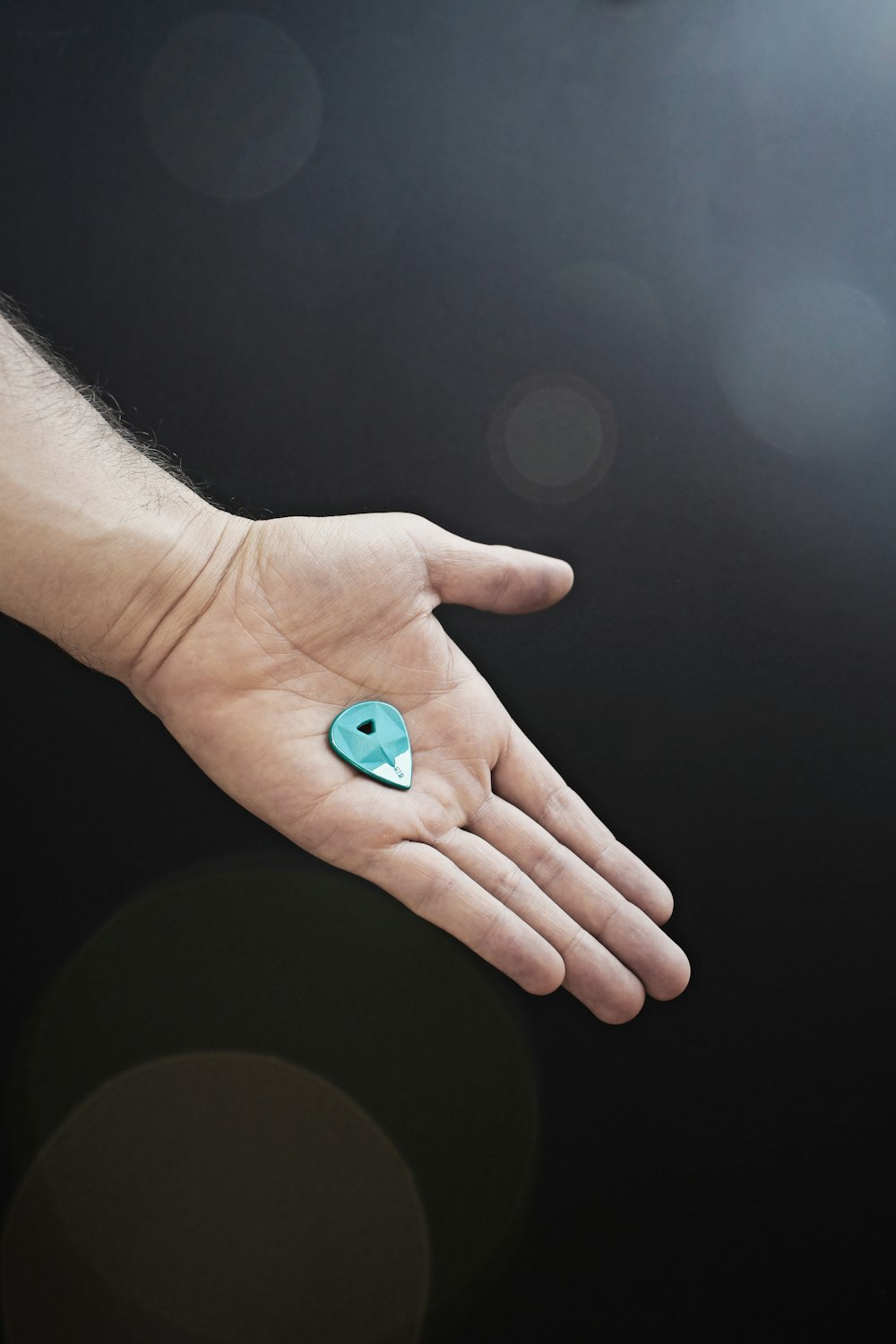 person holding blue heart ornament