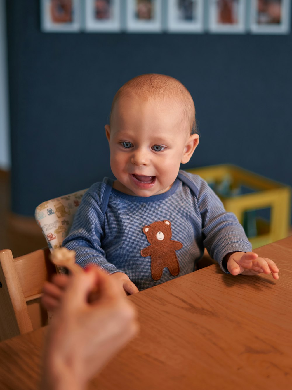 bambino in maglione blu seduto su seggiolone di legno marrone