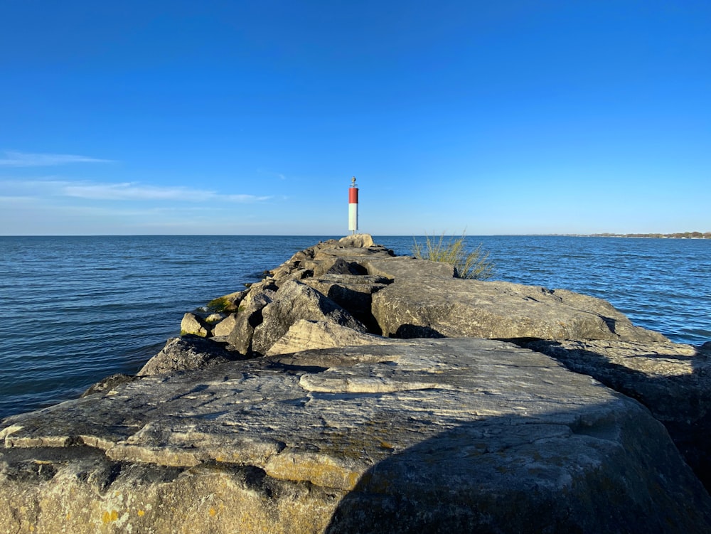 a light house sitting on top of a large rock next to the ocean