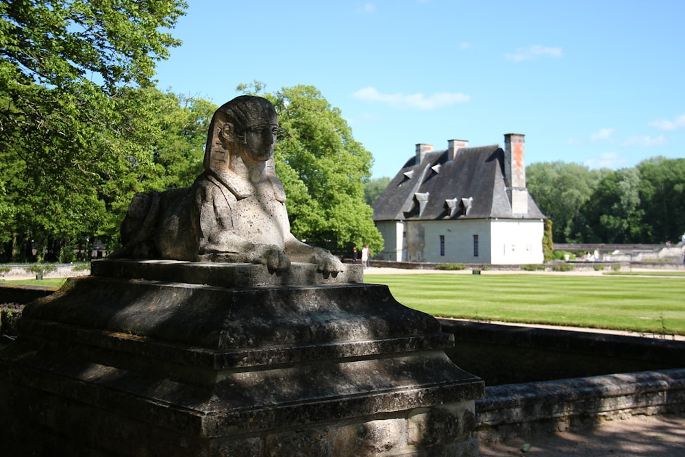 gray concrete statue near green grass field during daytime