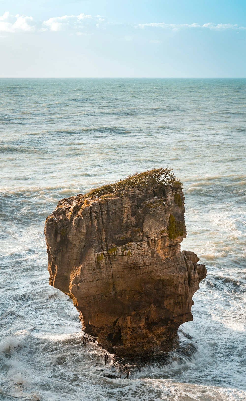 brown rock formation on sea during daytime