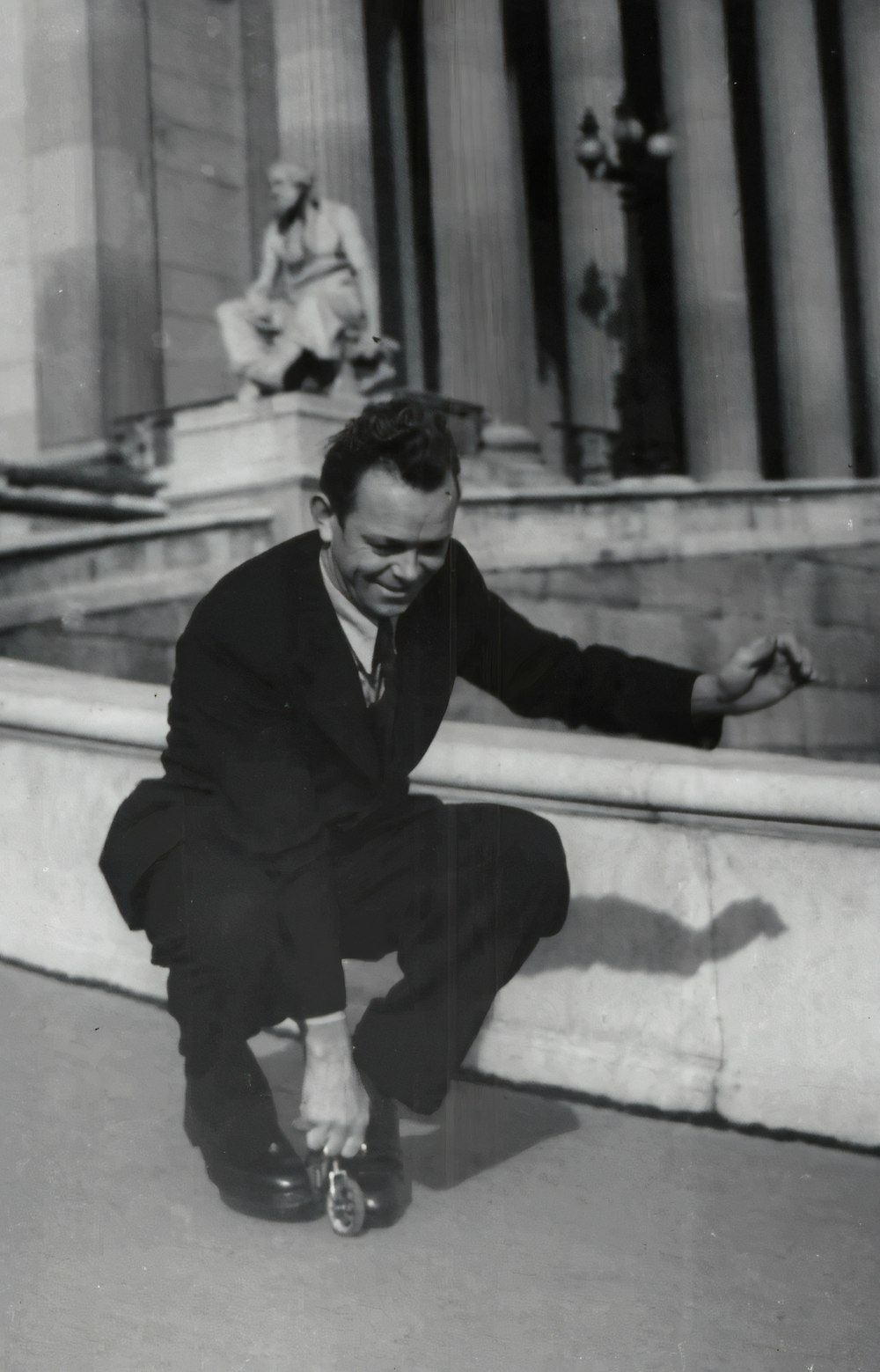 man in black suit sitting on concrete bench