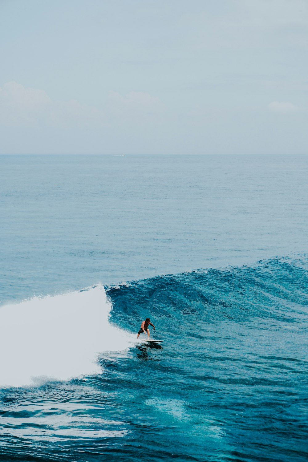 man surfing on sea waves during daytime