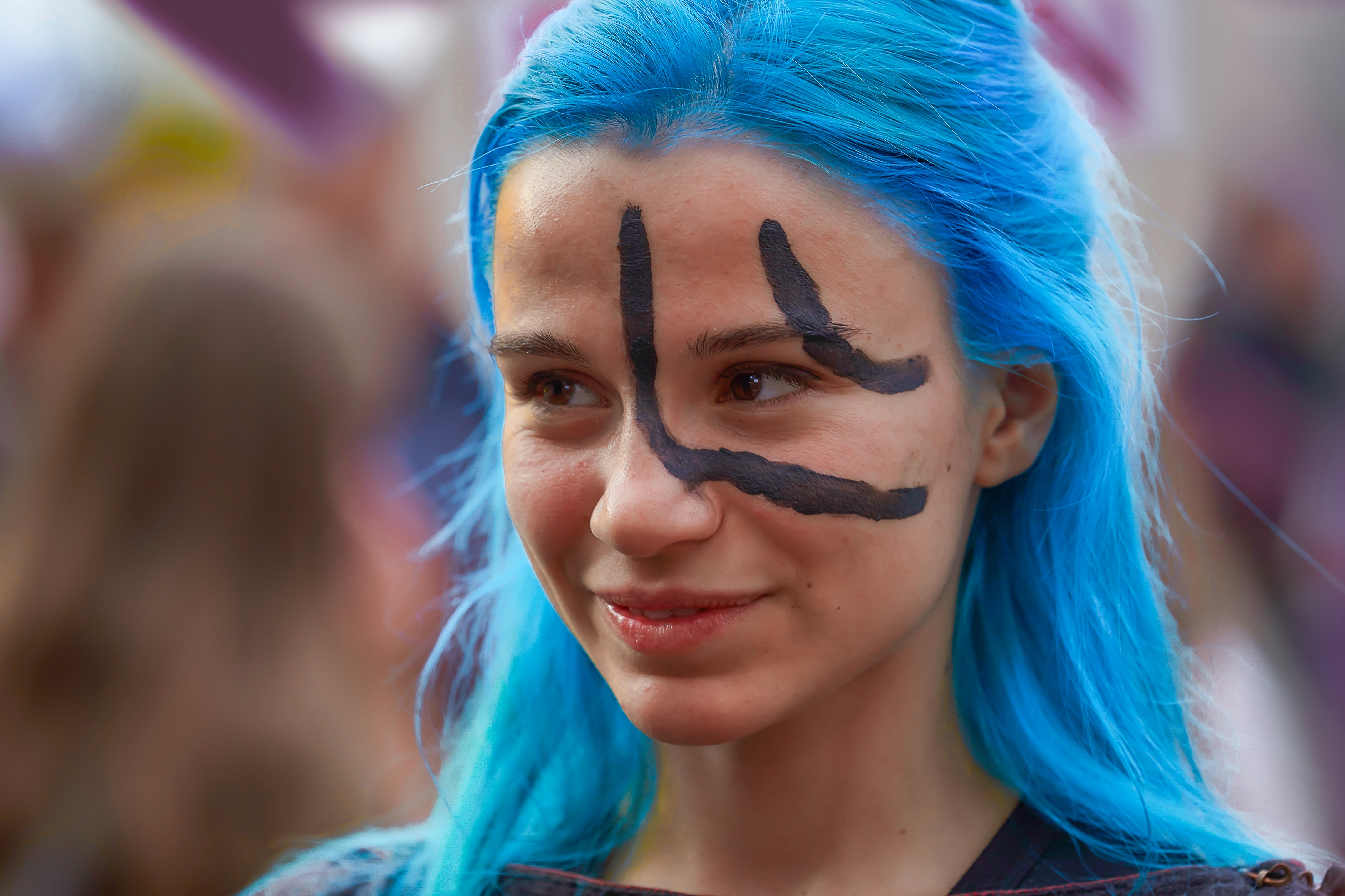 Wanita dengan rambut biru dengan cat hitam di wajah