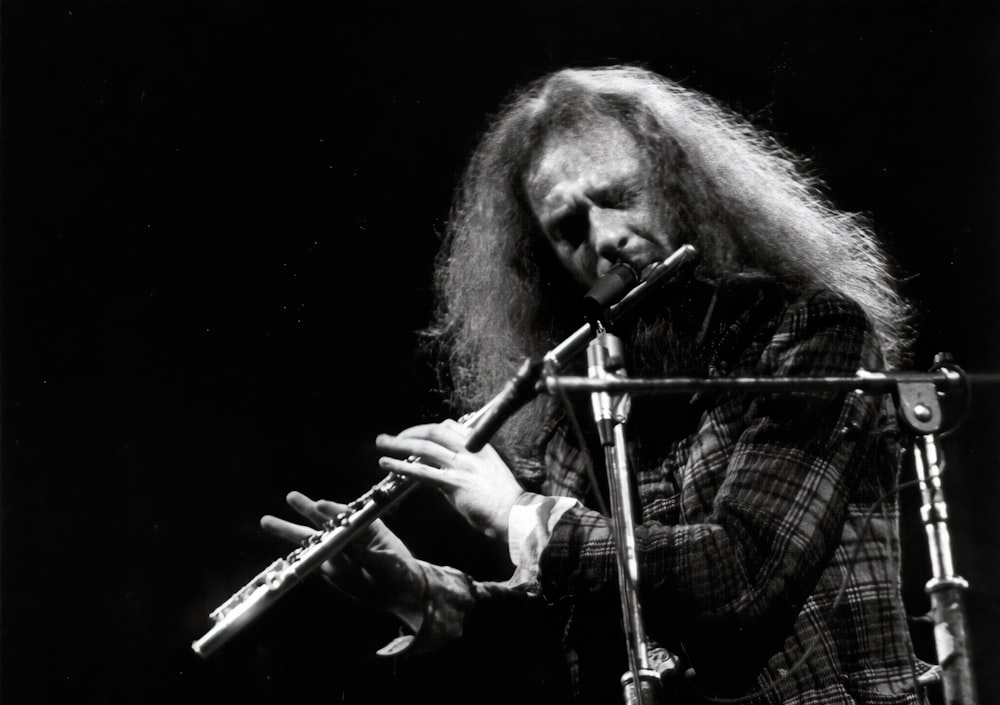 man in plaid shirt playing flute