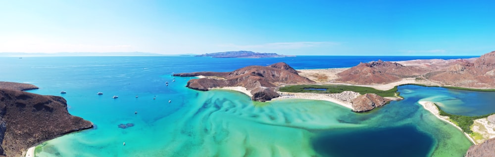 Isola verde e marrone sul mare blu sotto il cielo blu durante il giorno