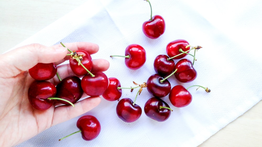 red cherries on white textile