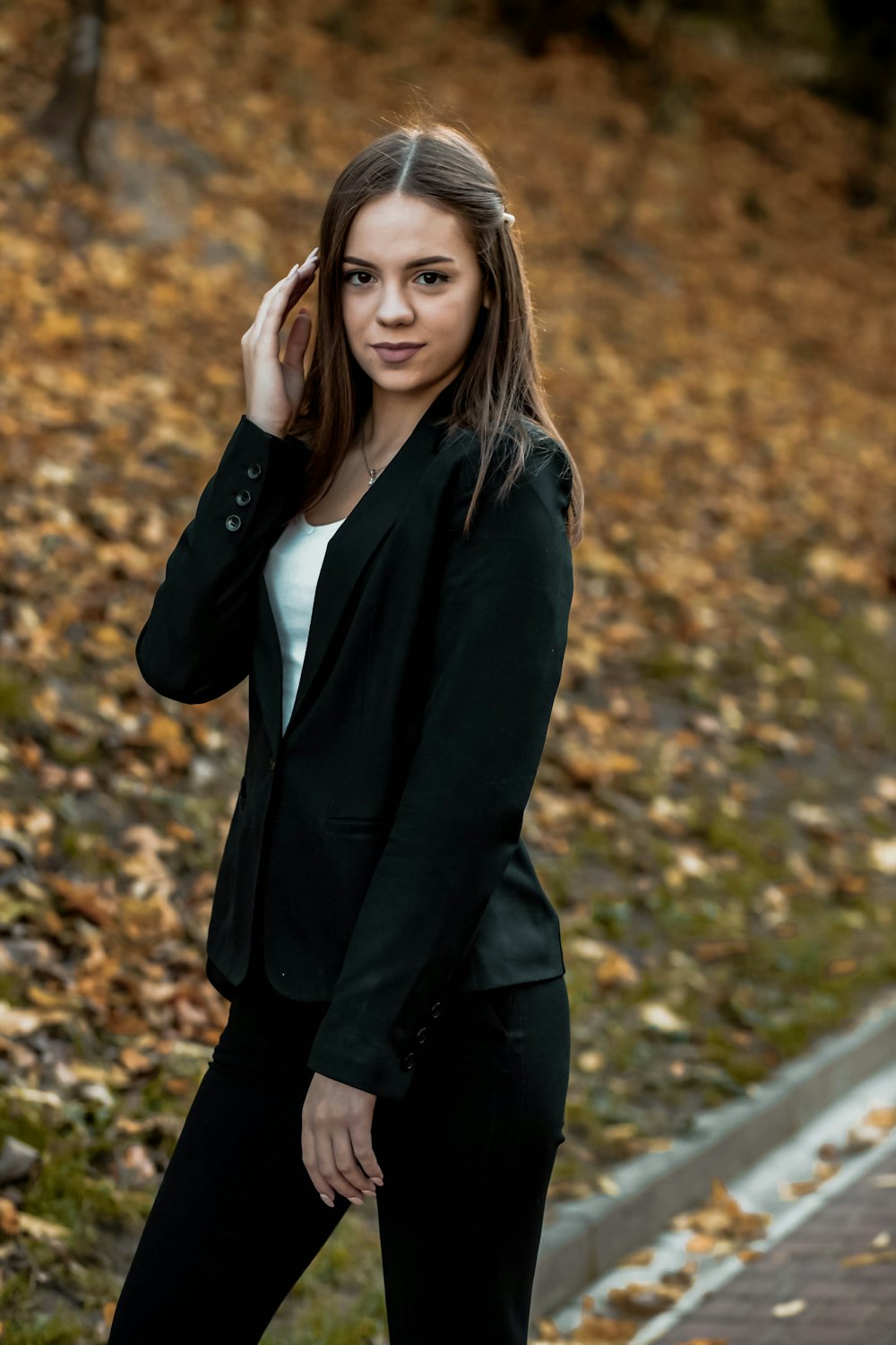 woman in black blazer standing on road during daytime