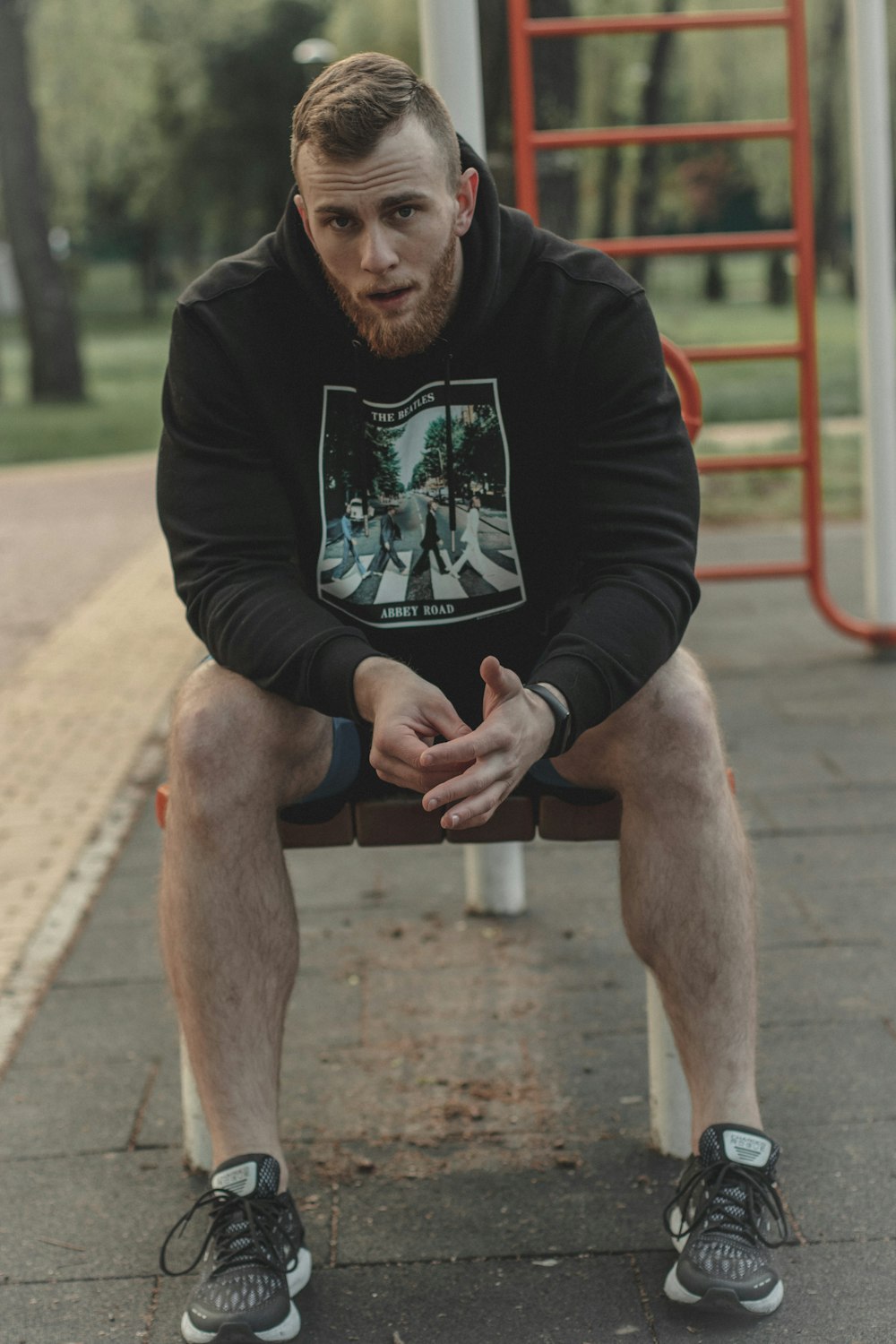 man in black crew neck long sleeve shirt sitting on brown wooden bench during daytime