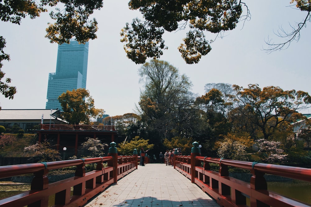 brown wooden bridge near green trees during daytime