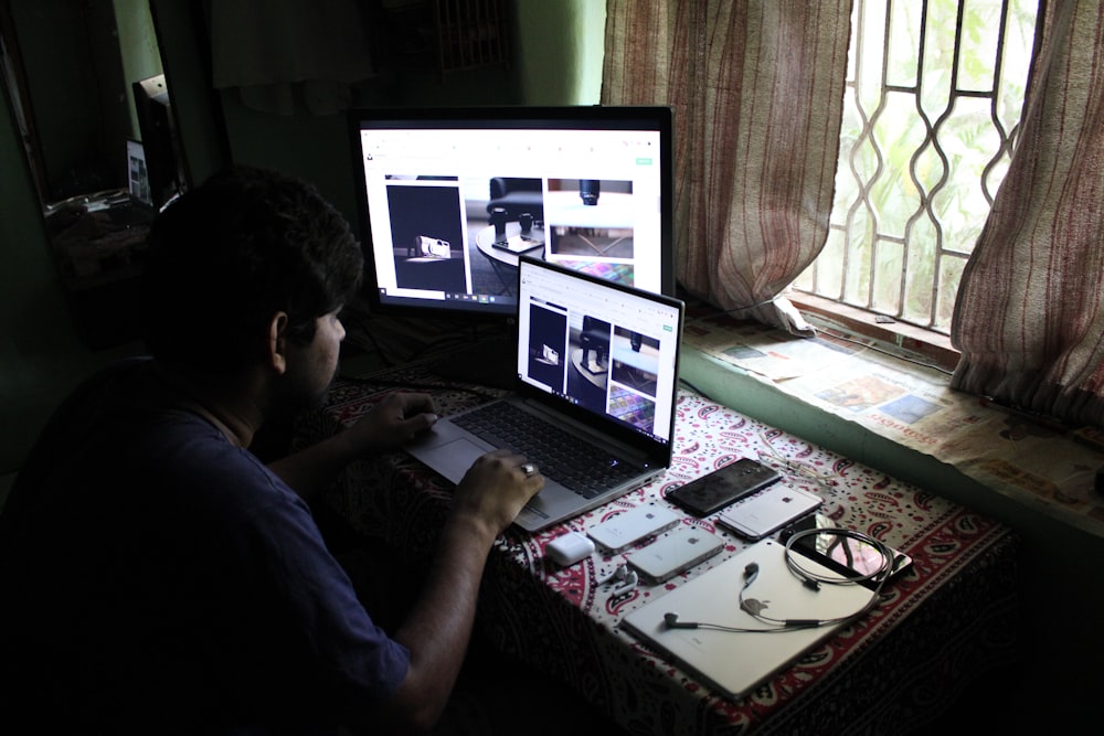 man in black shirt using laptop computer