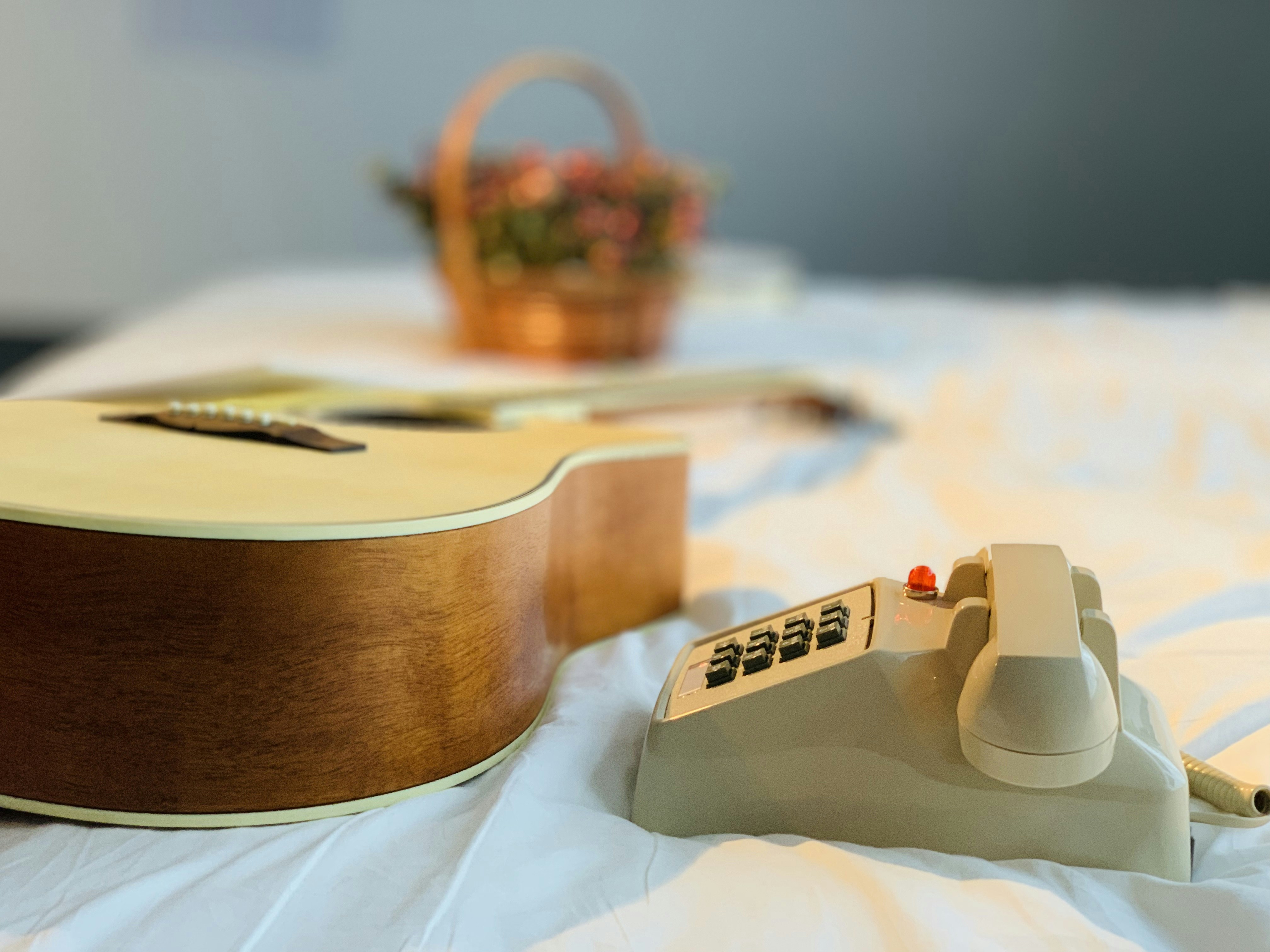brown acoustic guitar on white textile
