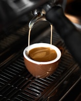 Barista pouring a smooth espresso shot into a ceramic cup.