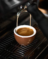 Close-up of freshly brewed coffee pouring from a Jura machine after service.