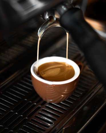 Close-up of a barista expertly pouring a creamy espresso shot with rich crema.