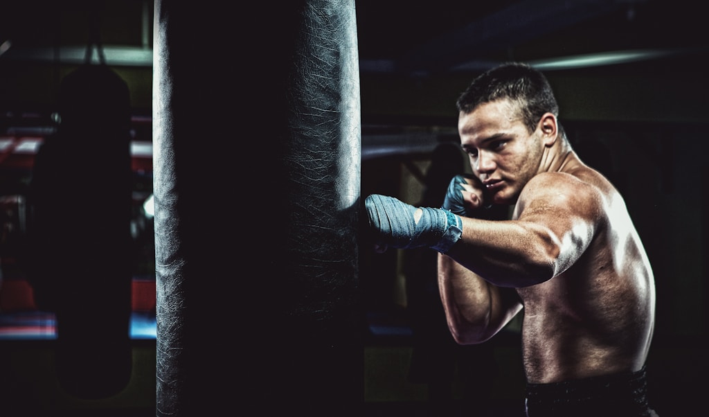 man in blue pants and black boxing gloves