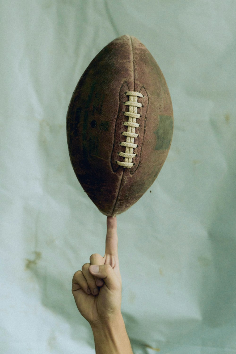 person holding brown football ball