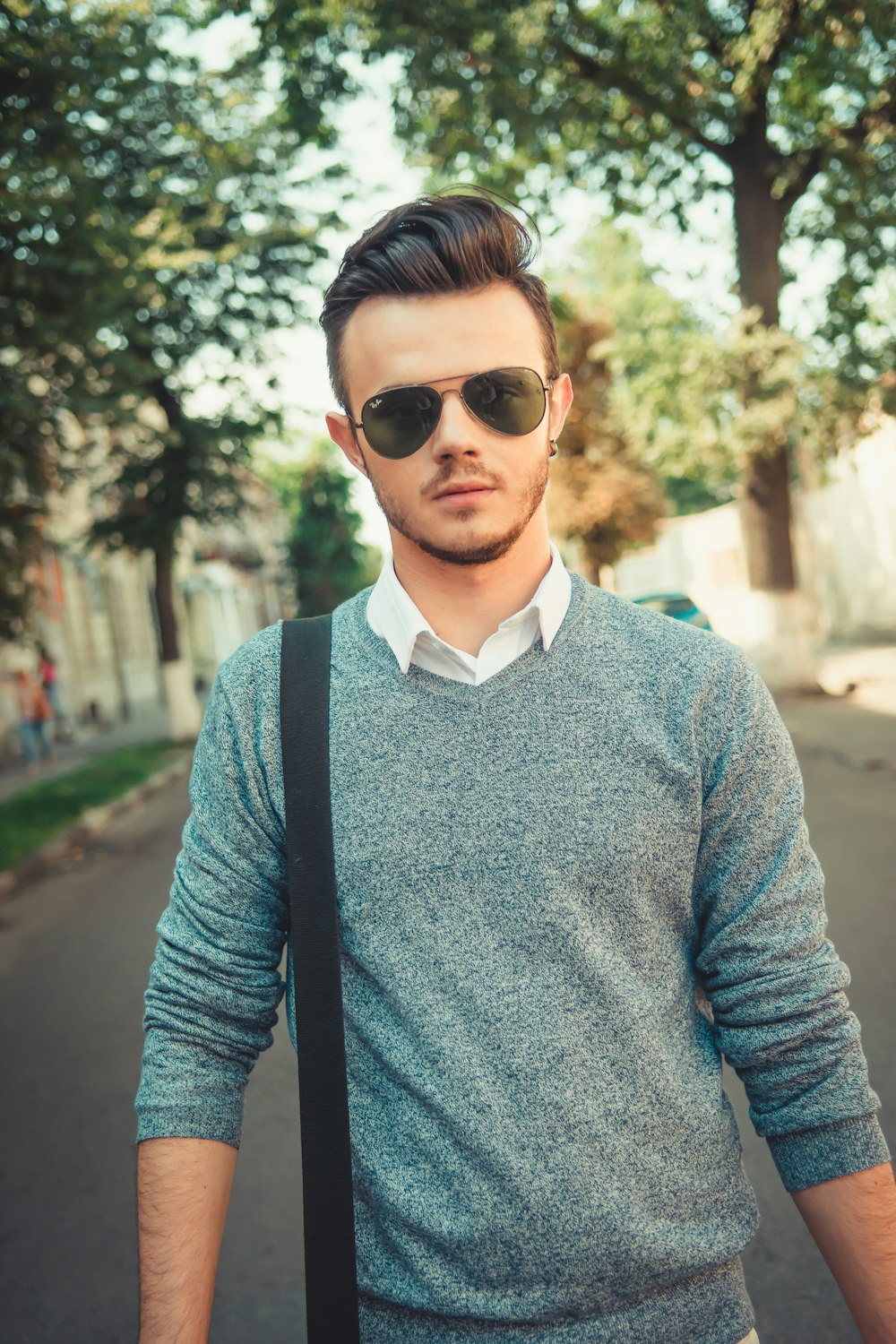 man in blue sweater wearing black sunglasses