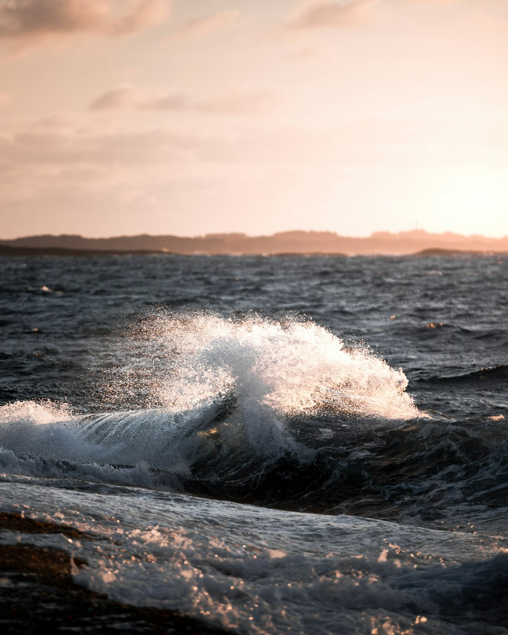 ocean waves crashing on brown rock during daytime