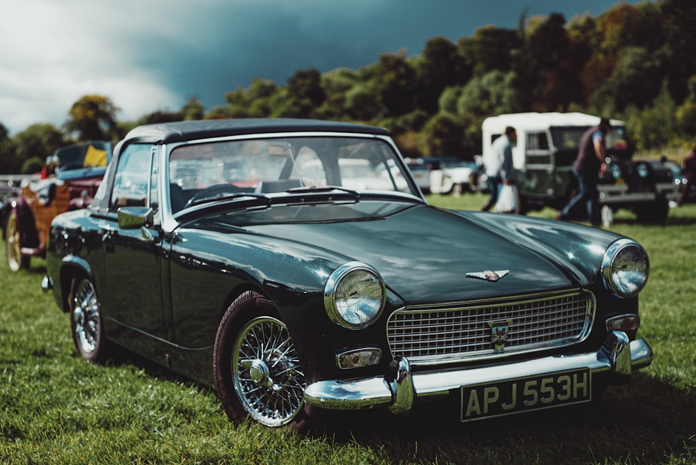 blue mercedes benz coupe on green grass field during daytime