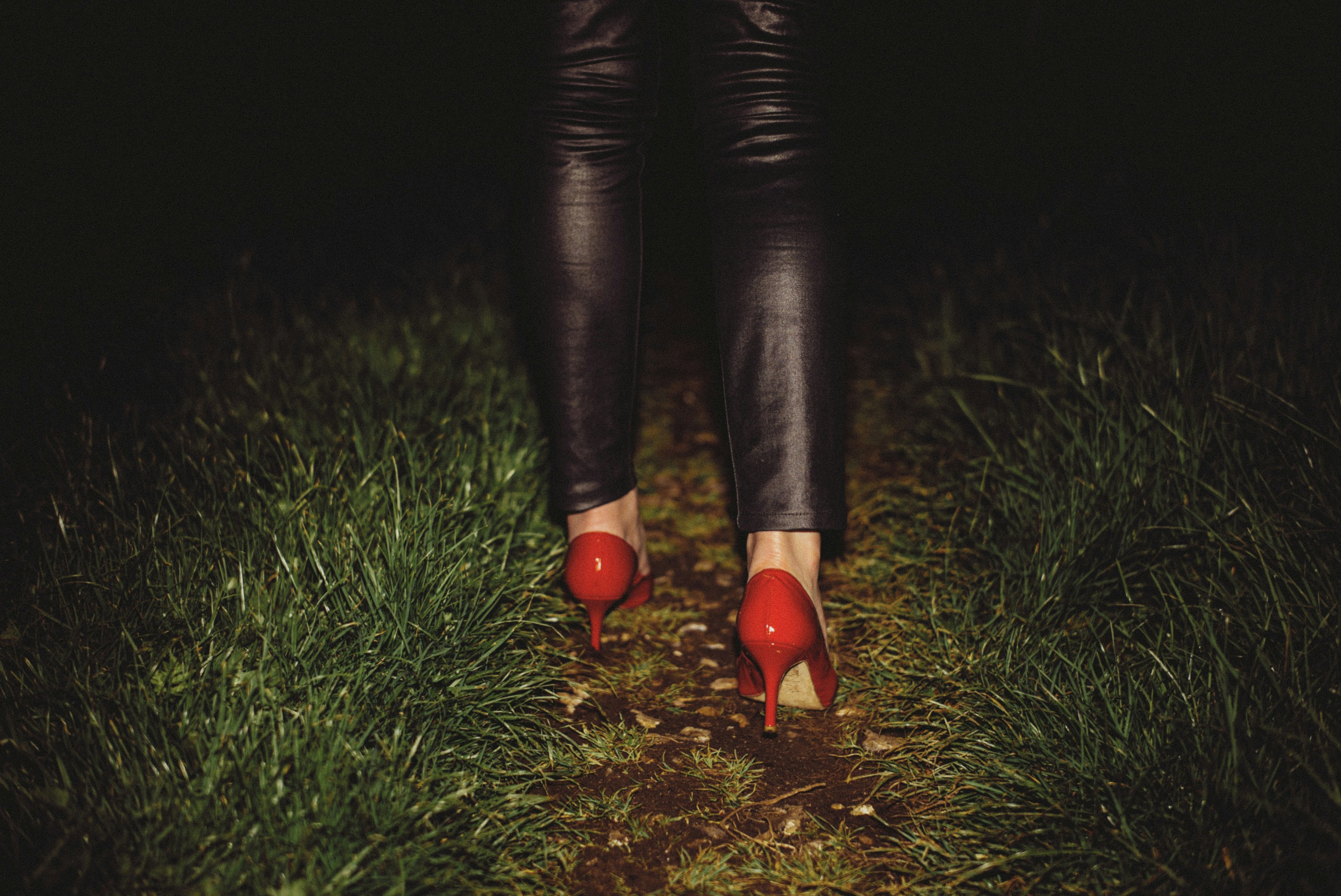 a woman's legs wearing red high heeled shoes