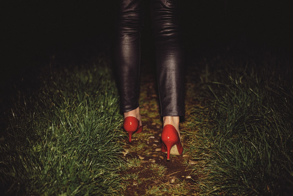 a woman's legs wearing red high heeled shoes