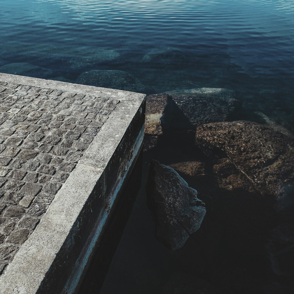 gray concrete dock near body of water during daytime