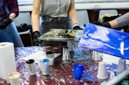 person in gray t-shirt painting on table