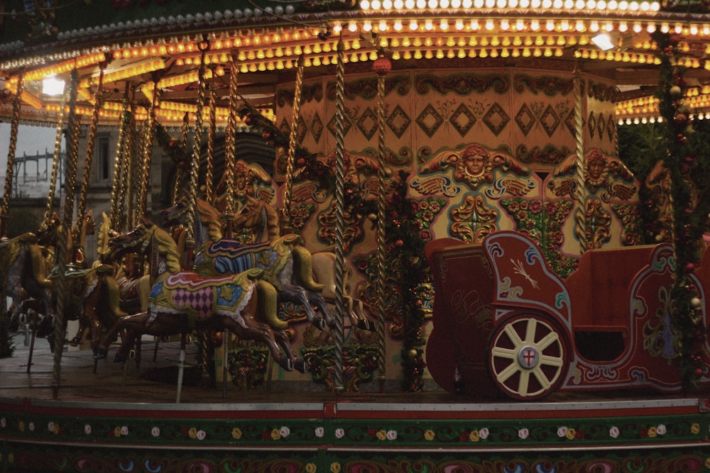 red and gold carousel with people riding