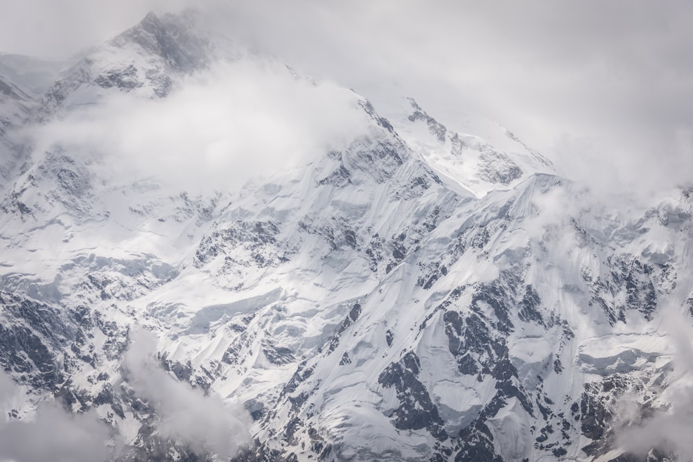 montanha coberta de neve sob céu nublado durante o dia