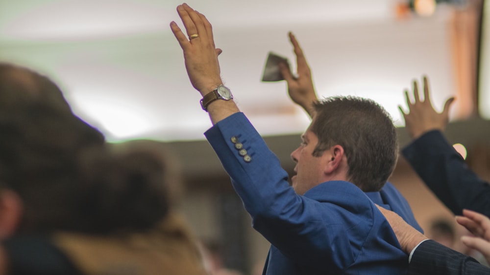 man in blue long sleeve shirt holding white paper