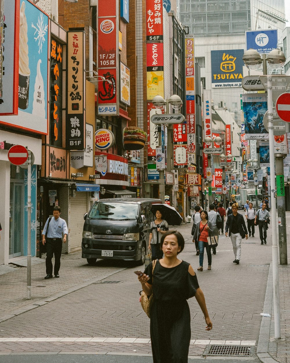 man in black crew neck t-shirt walking on sidewalk during daytime