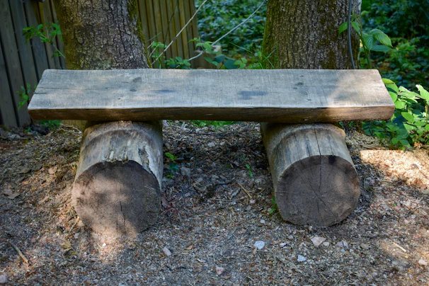 Rustic outdoor bench made from reclaimed wood, set in a sunny garden