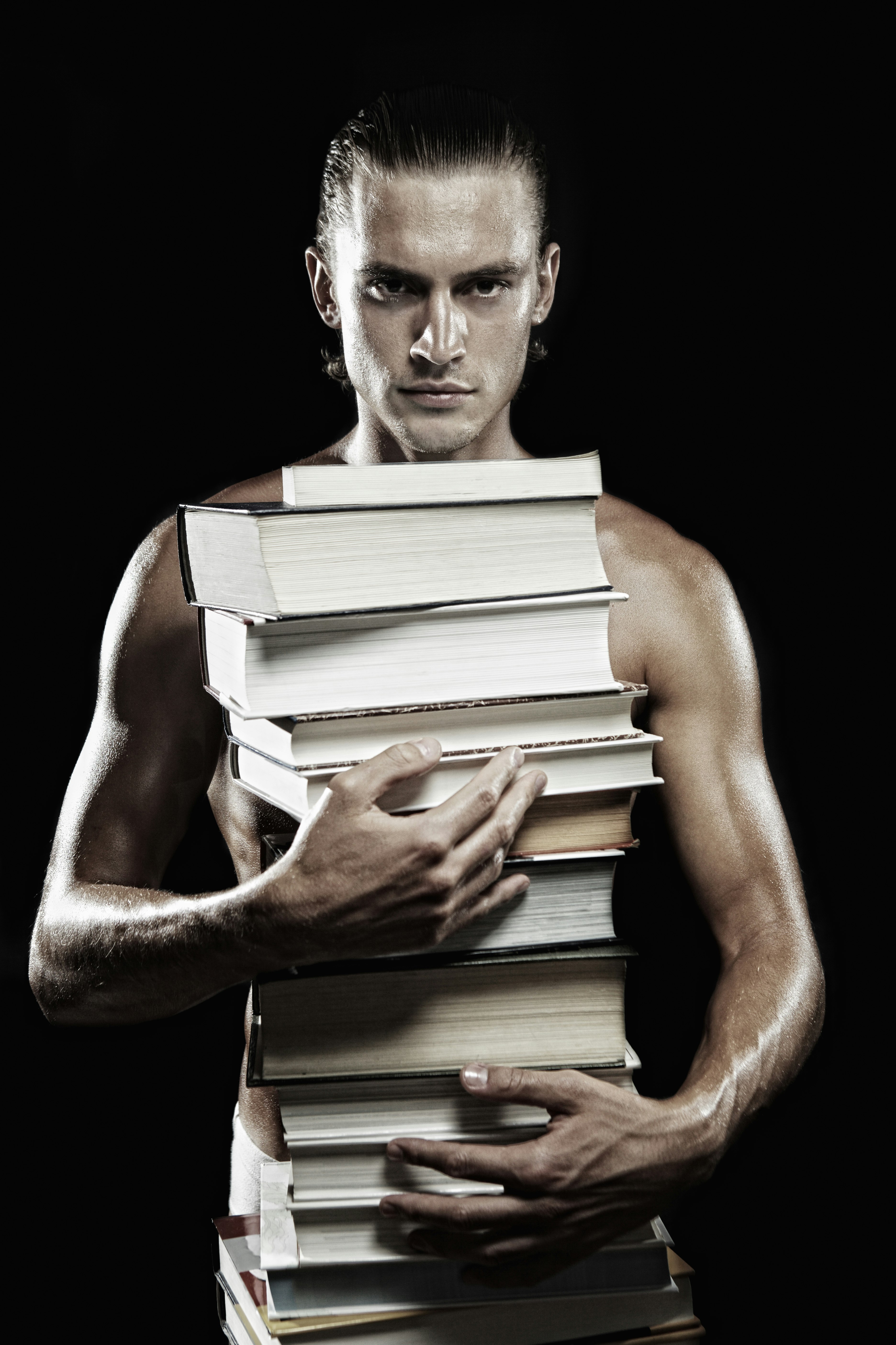 man holding books with black background