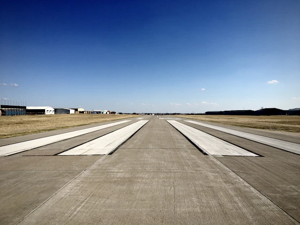 A wide shot of a military airbase runway being restored with high-precision equipment.