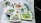 A collection of cartoonish and vibrant stickers featuring various humorous and playful characters, including a caveman with a cigar, smiling green creatures, and quirky designs. Each sticker is colorful and arranged in a casual, overlapping manner on a surface.
