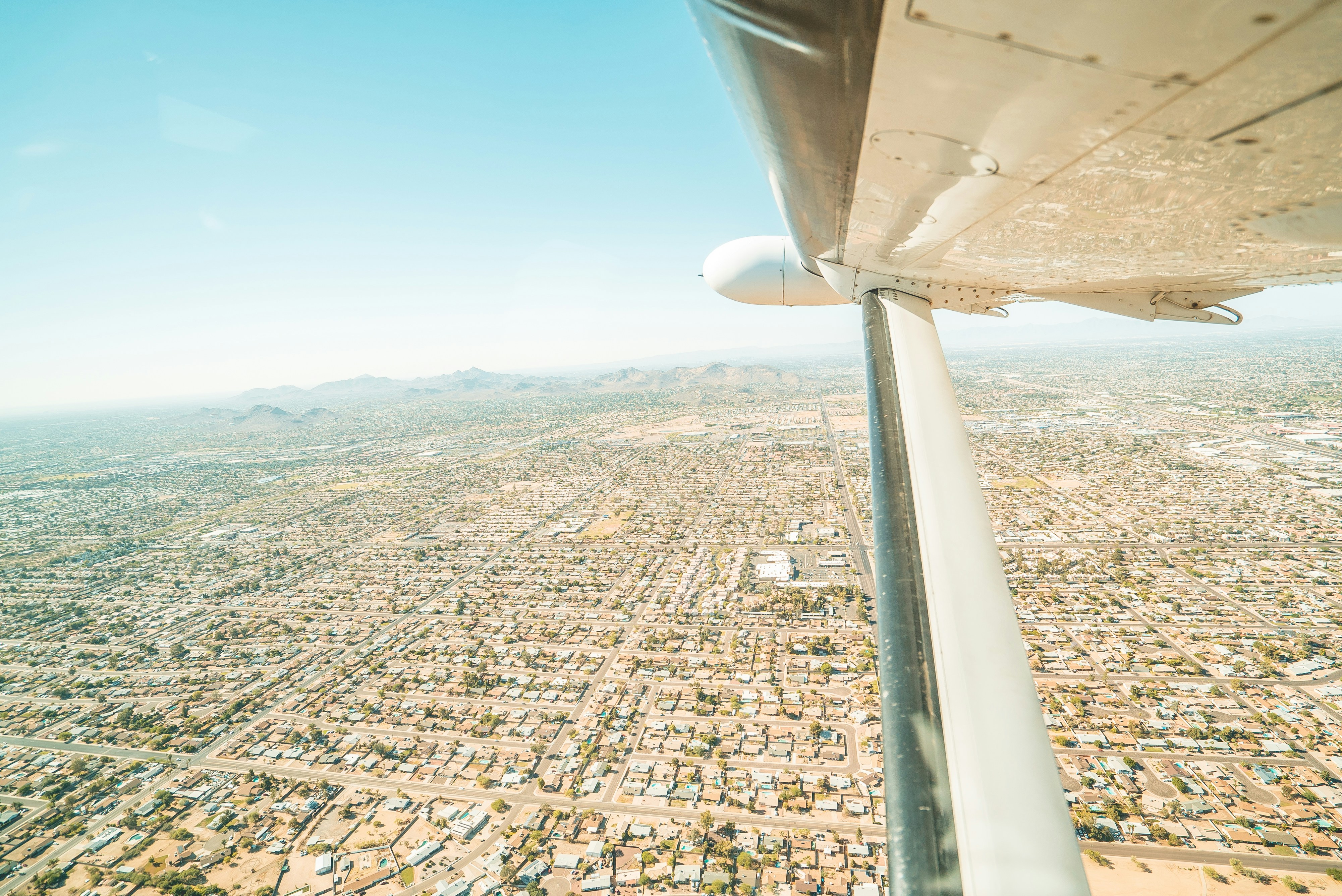 Aile d’avion blanche au-dessus de la ville pendant la journée