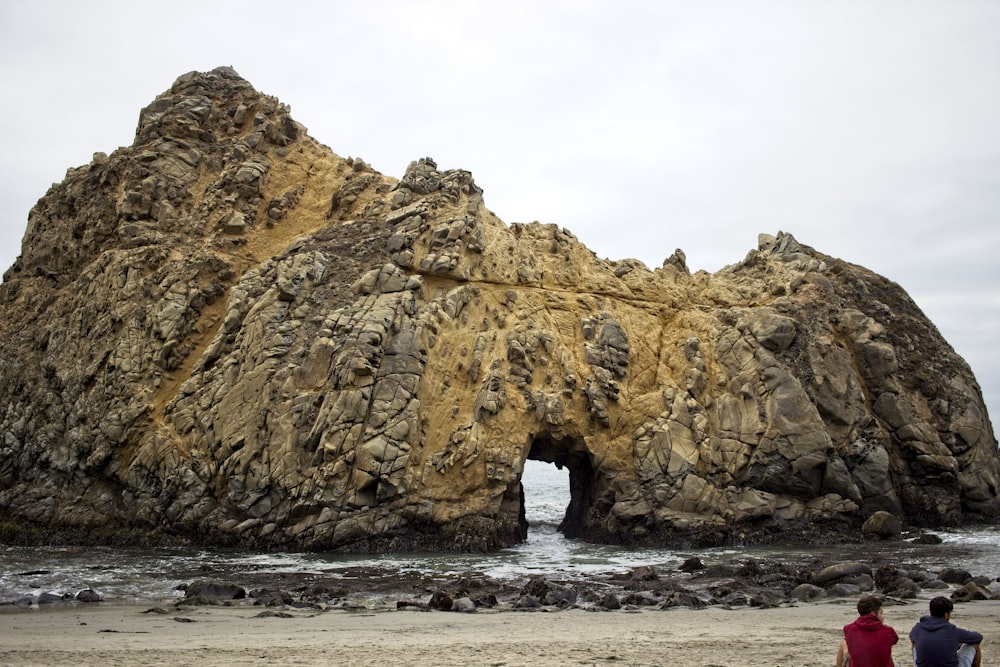 brown rock formation on sea water under white sky during daytime