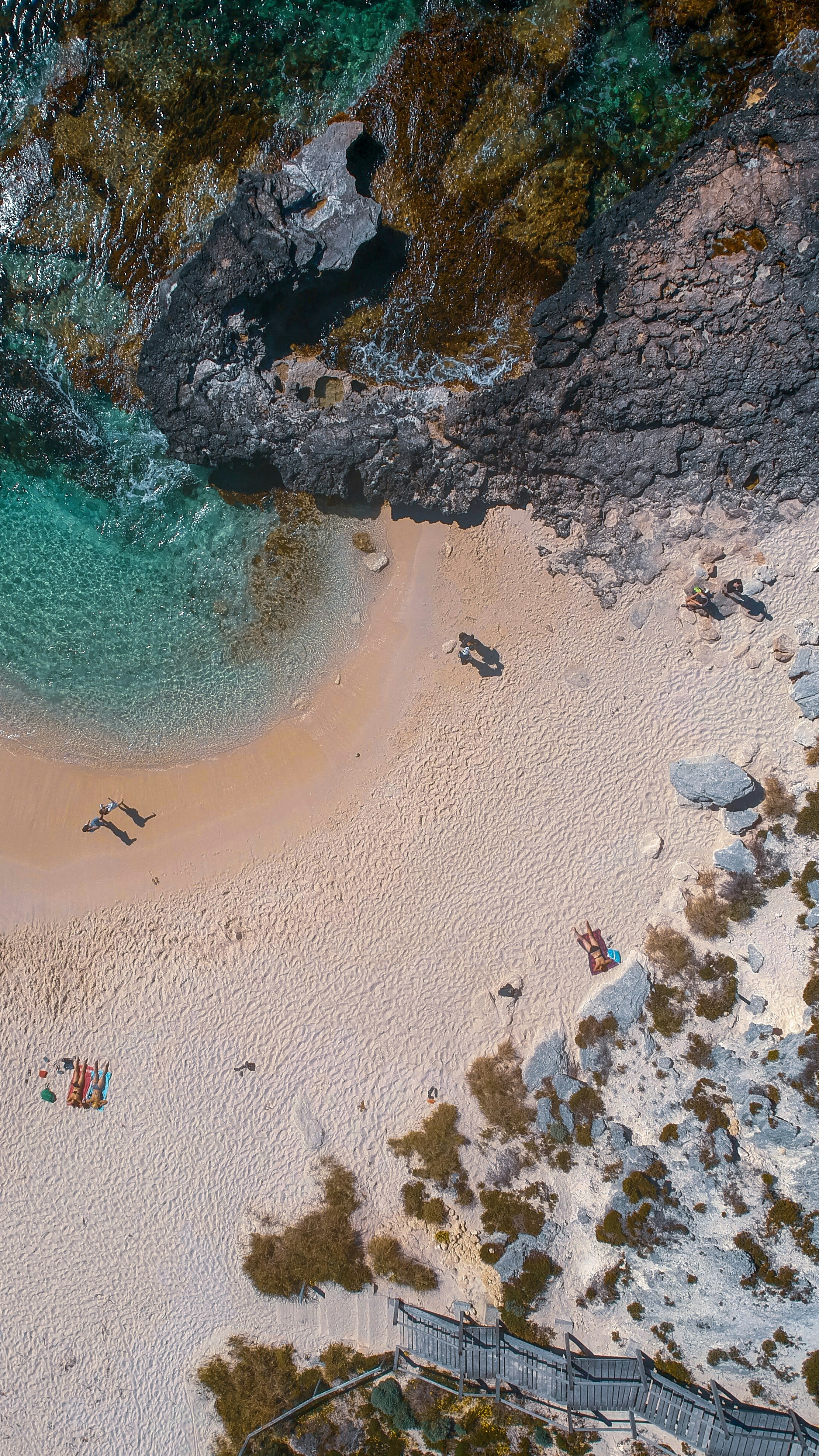 an aerial view of a sandy beach with people on it