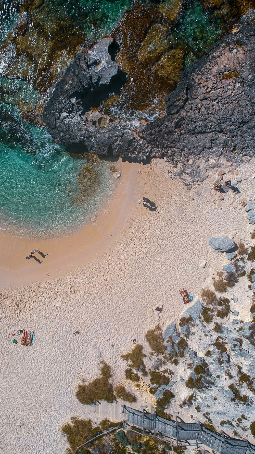 an aerial view of a sandy beach with people on it
