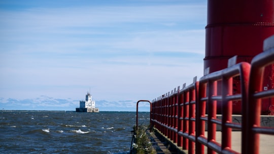 red metal fence near body of water during daytime in Lakeshore State Park United States