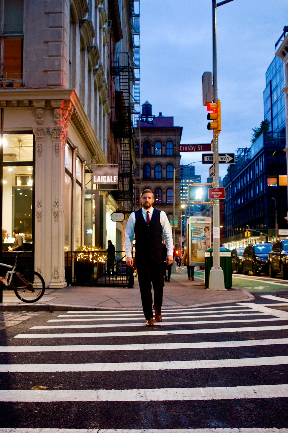 man in black suit standing on pedestrian lane during night time