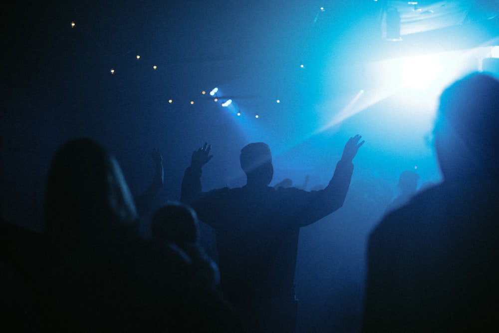 silhouette of people standing in front of stage