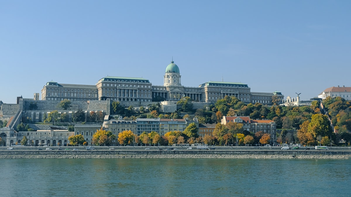 Budapest June — Buda Castle dome and white towers overlooking the Danube on a summer afternoon
