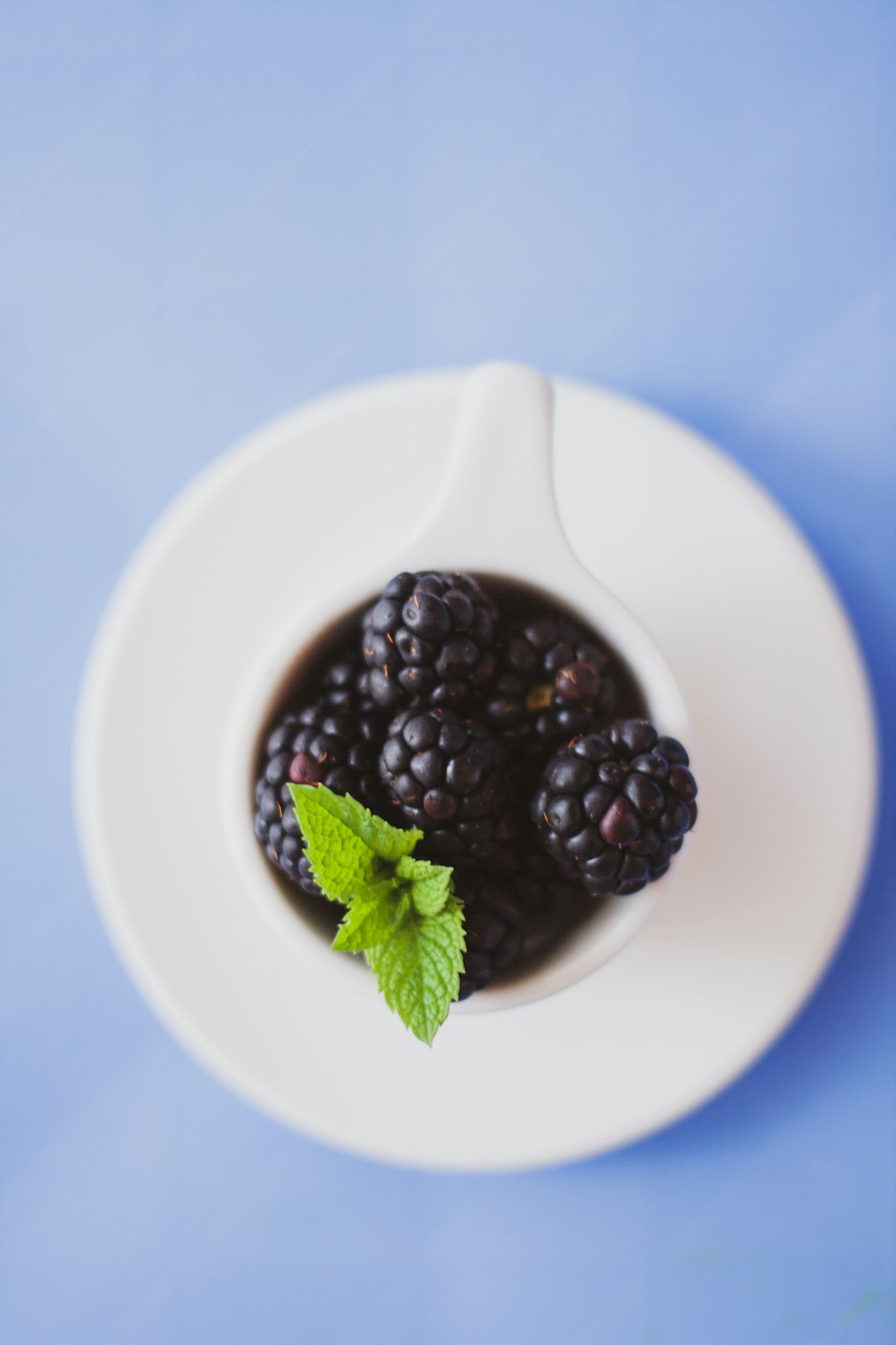 black round fruit on white ceramic bowl