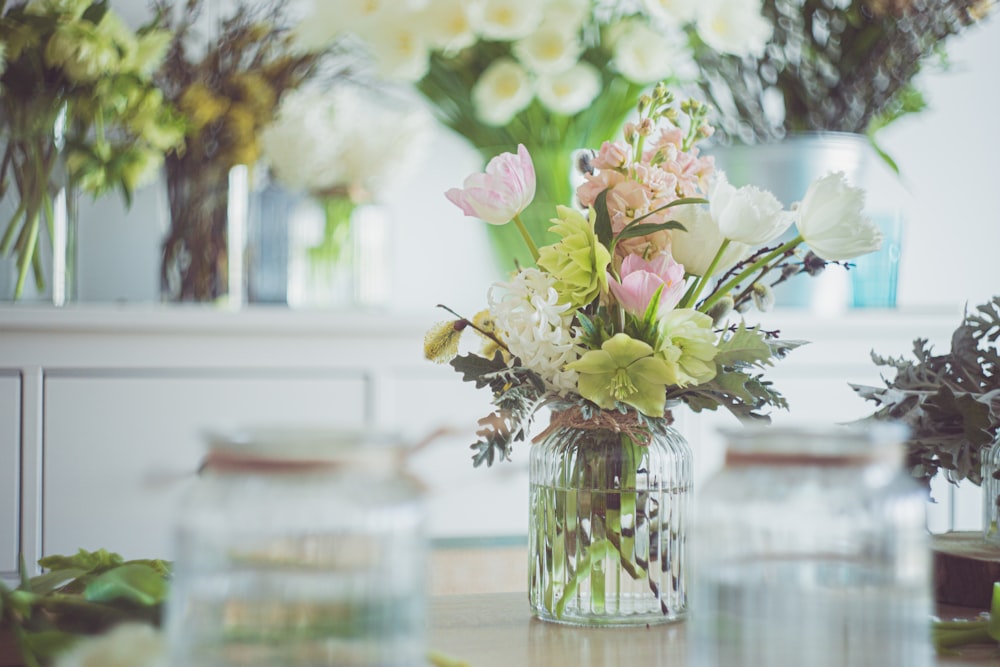 pink and white flowers in clear glass vase