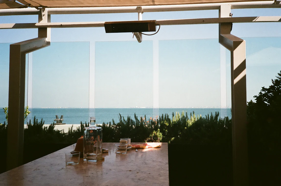 Mesa de pequeno-almoço sob uma pérgula, com vista para o mar