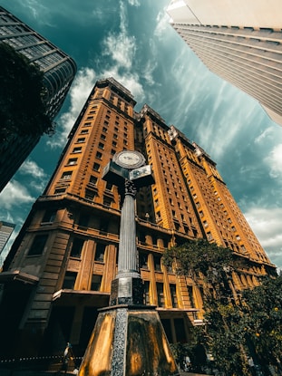 brown and white concrete building under white clouds and blue sky during daytime