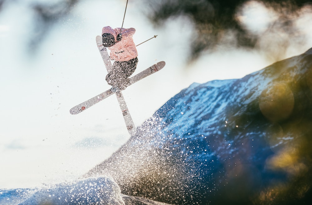 man in red jacket and black pants riding on snowboard during daytime