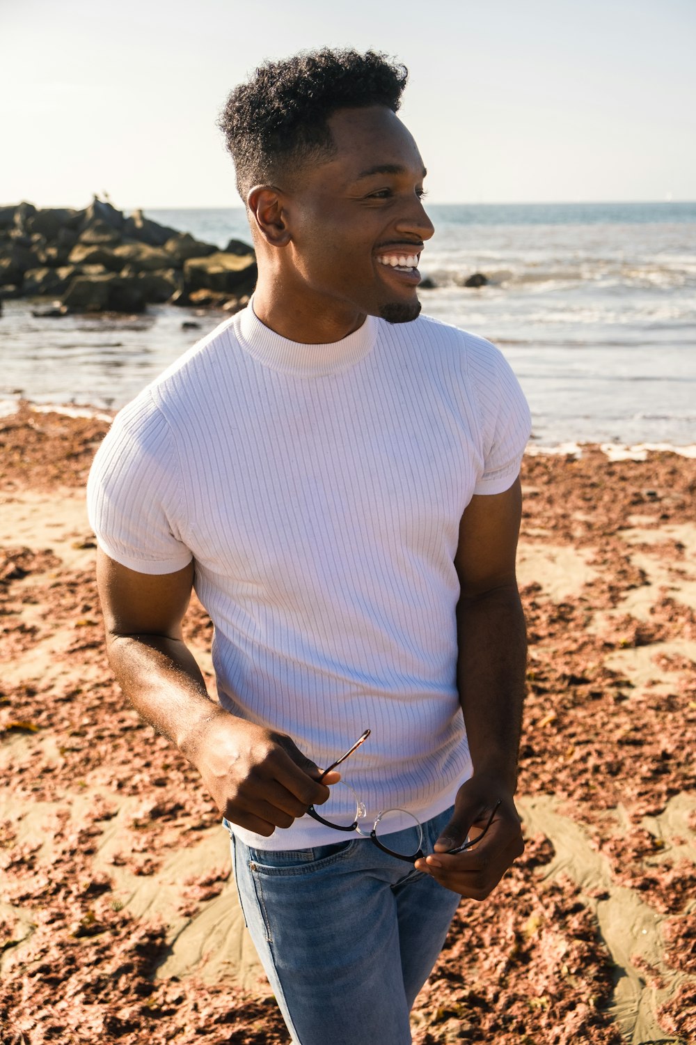 man in white crew neck t-shirt standing on beach during daytime